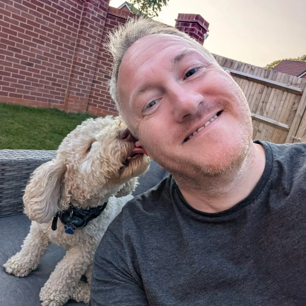 Jonathan, the author of the blog, smiling with his cockapoo